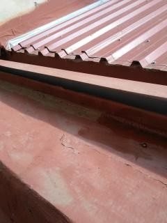 Pretil con grietas y manchas de humedad bajo el alero